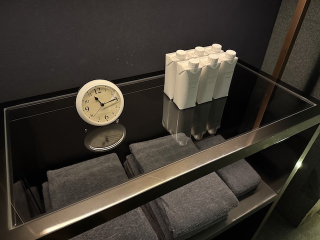 HOTEL THE MITSUI KYOTOのスパに置いてある水と時計、タオル